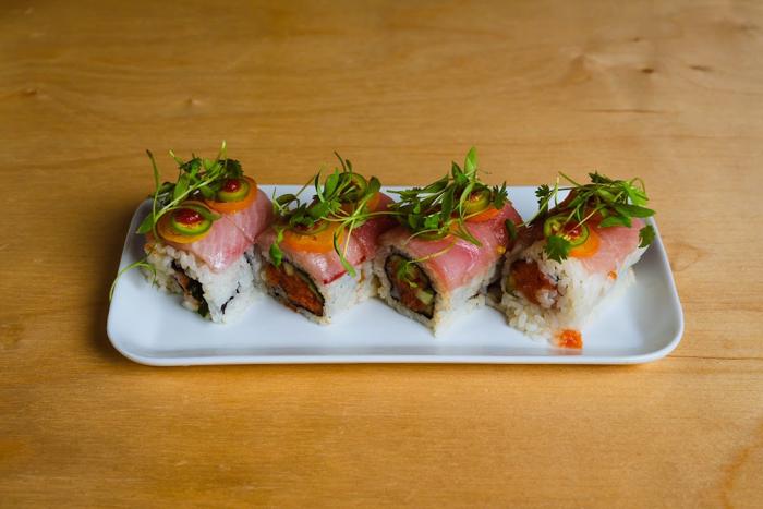 Hanamokoshi roll topped with hamachi and kumquats